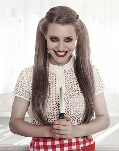 do you have the courage to ea from the dinner she will made? Halloween concept with woman holding knife and looking at camera.