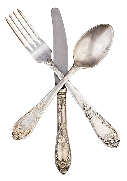 istock Old silver knife fork and spoon crossed isolated 603174006