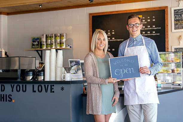 istock Young heterosexual couple holding a open sign 603175220