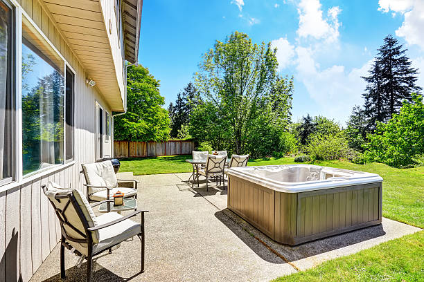 istock Backyard concrete floor patio area with hot tub. 603182282