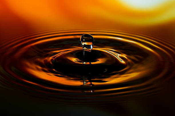 istock Close-up of water drop on yellow orange background 603182412