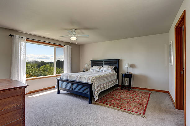 istock Bedroom interior with beige walls, rug and white curtains 603182918