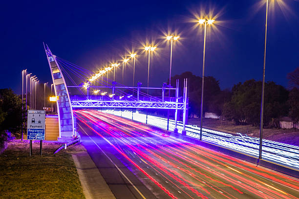 Tolling gates on the Western bypass highway seen in the evening with the illuminated lights, and its unique design, different from other toll gates.