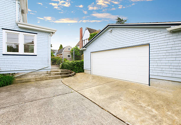 istock Separate garage with blue and white trim and driveway. 603185028