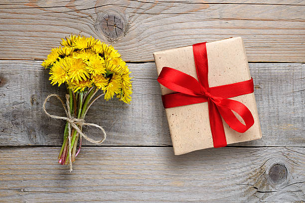 istock Dandelion flowers and gift box on wooden background 603186412