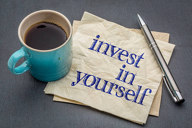 Invest in yourself advice Invest in yourself advice or reminder - handwriting on a napkin with cup of coffee against gray slate stone background self improvement stock pictures, royalty-free photos & images