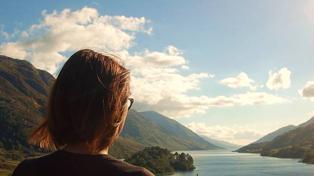 istock Person looking at lake and mountain landscape 603188326