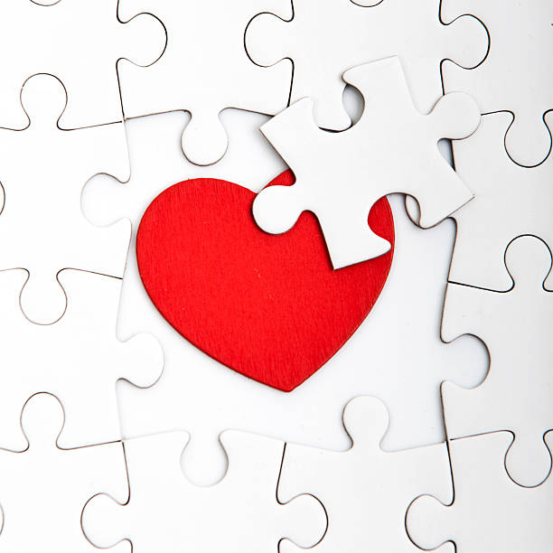 istock Jigsaw puzzle with blank white pieces and red heart. 603190336