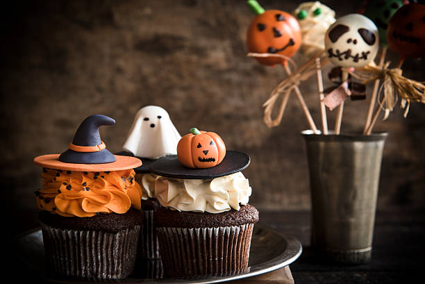 Funny Halloween desserts Funny cup cakes and cake pops as Halloween decoration on the wooden background,selective focus halloween cupcake stock pictures, royalty-free photos & images