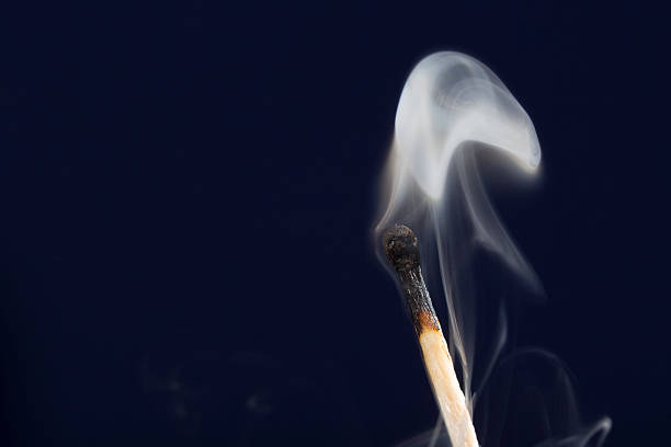 istock Extinguished match with smoke on dark blue background 603191838