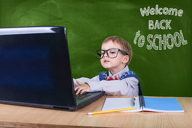istock Child with laptop peeking in the classroom 603193308