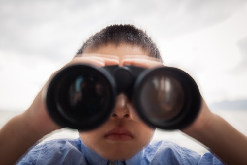 Young boy look through binoculars