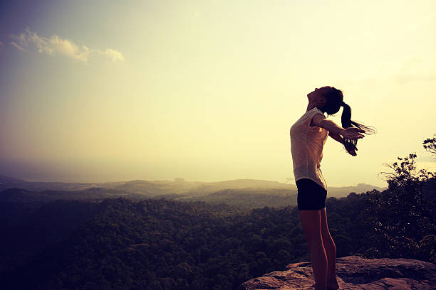istock young freedom woman open arms on mountain peak 603197332