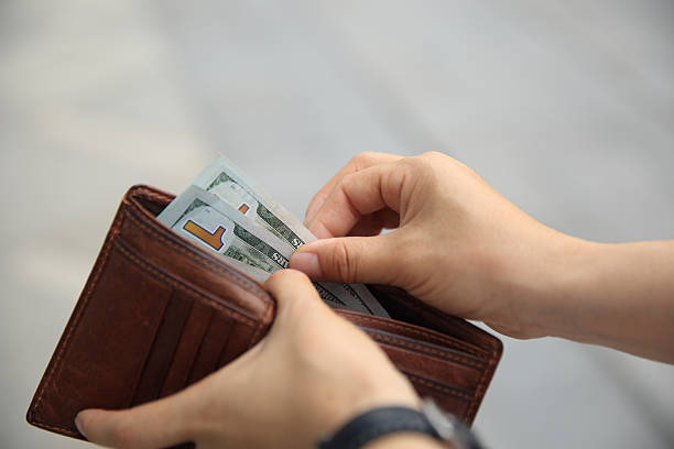 istock Hands taking  us dollars  out from wallet on the street 603197356
