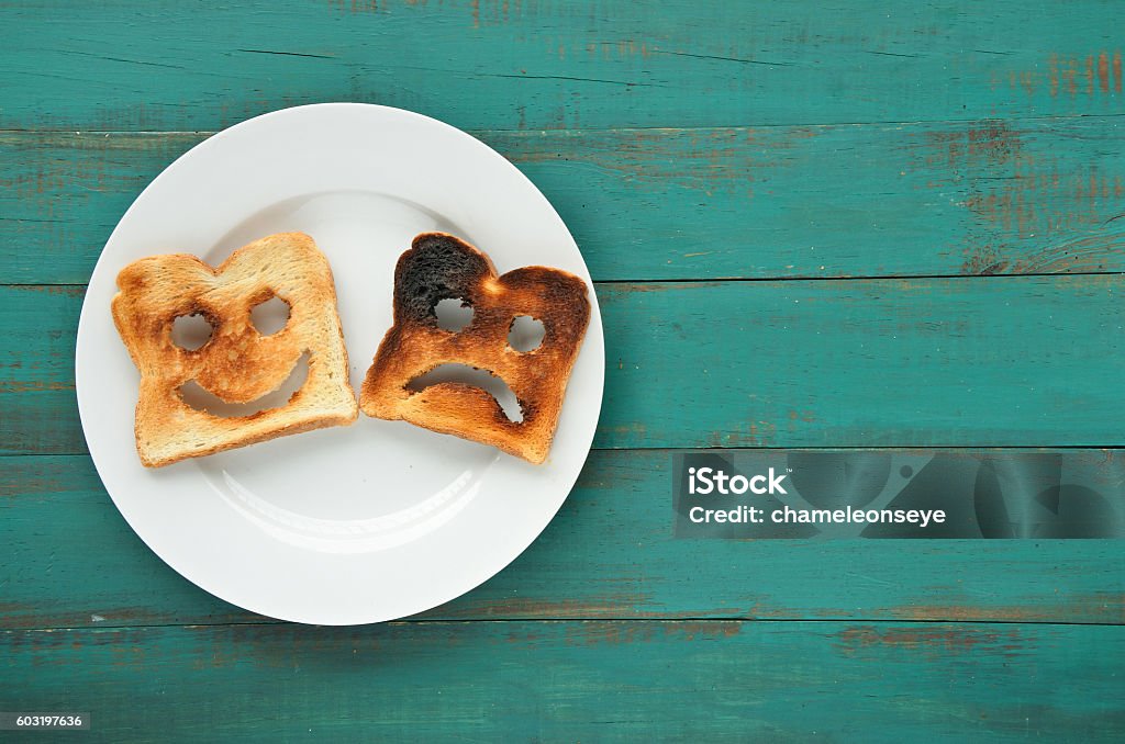 Flat lay view of two slices of toasted bread Flat lay view of two slices of toasted bread in a white plate. One is burned and one is well done. Relationship lifestyle concept. copy space Food Stock Photo