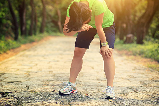 istock tired woman runner taking a rest after running hard 603198558