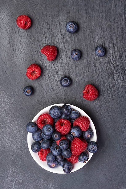 istock fresh raspberries  and bilberry berries 603198734