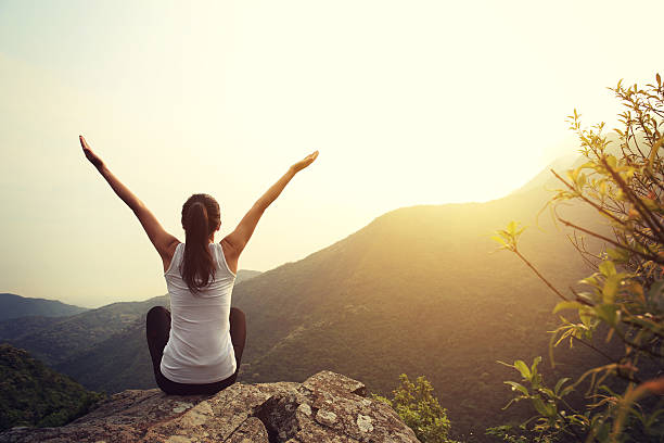 istock young woman practice yoga at mountain peak cliff 603198800
