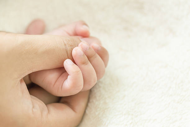 istock Baby hand holding finger mom on vintage tone. (Selected focus) 603199774