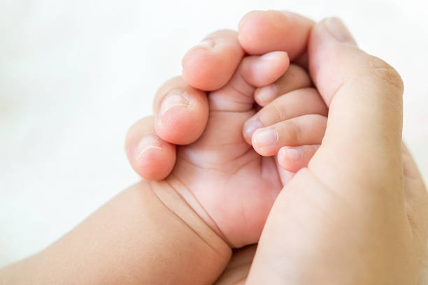 istock Mather hand holding baby hand on white background. 603199944