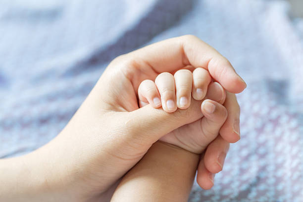 istock Baby hand holding finger mom. (Selected focus) 603200090