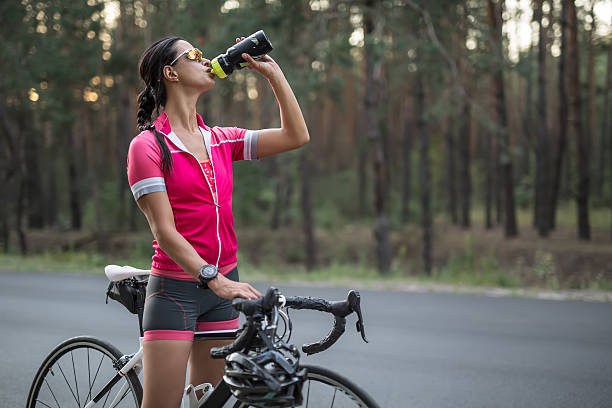 istock Girl with bike drinks from flask 603252878