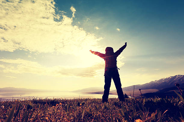 istock cheering successful woman backpacker open arms on mountain peak 603252994