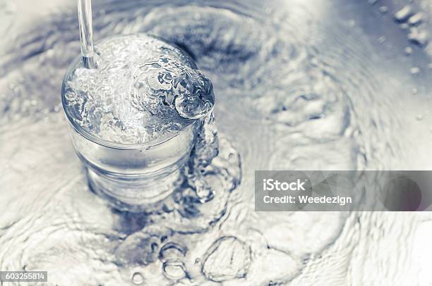 Pouring Water From Tap To Glass On Stainless Steel Stock Photo - Download Image Now - Faucet, Drinking Glass, Drinking Water