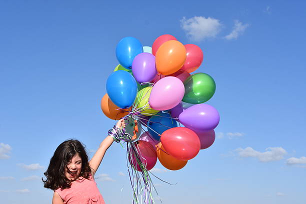 istock Girl holding balloons in nature 603257316