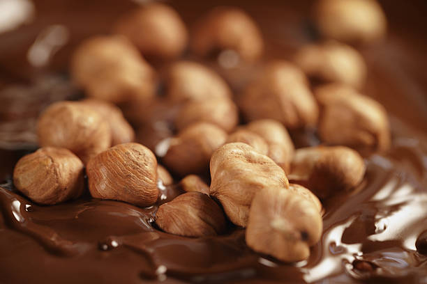 melted dark chocolate with hazelnuts, making chocolate bar stock photo