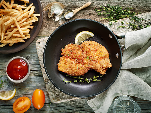 schnitzel on cooking pan schnitzel on cooking pan, top view schnitzel stock pictures, royalty-free photos & images