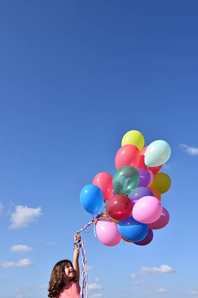 istock Girl holding balloons in nature 603258706