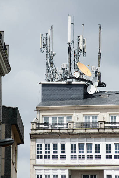 mobile telephony and television relay antennas on residential building roof. - television aerial roof antenna city imagens e fotografias de stock