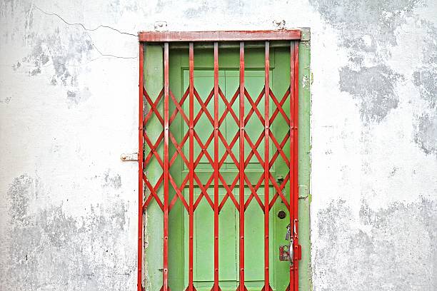 istock Old house wall with folding old red metal door gate 603261068