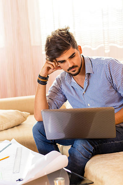 Young male student working at home.