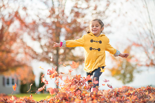 istock Little Girl Running Through a Leaf Pile 603262486