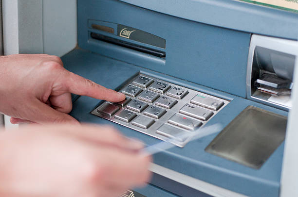 istock Man's Hand Using Card To Withdraw Money. ATM entering pin 603263216
