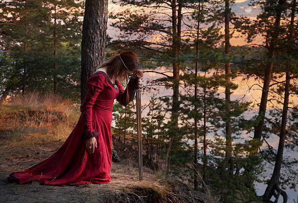 istock Young woman with a sword praying 603264850