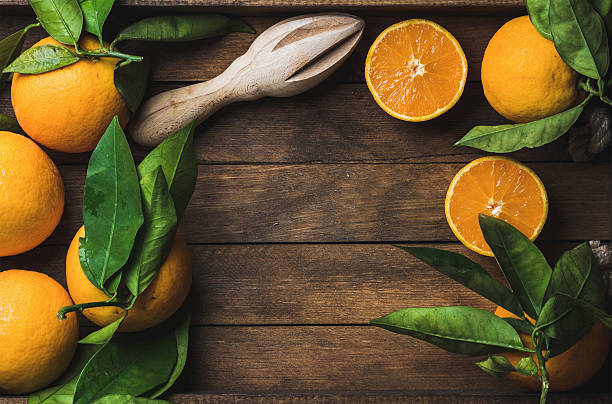 istock Fresh oranges with leaves in dark wooden tray over rustic 603267868