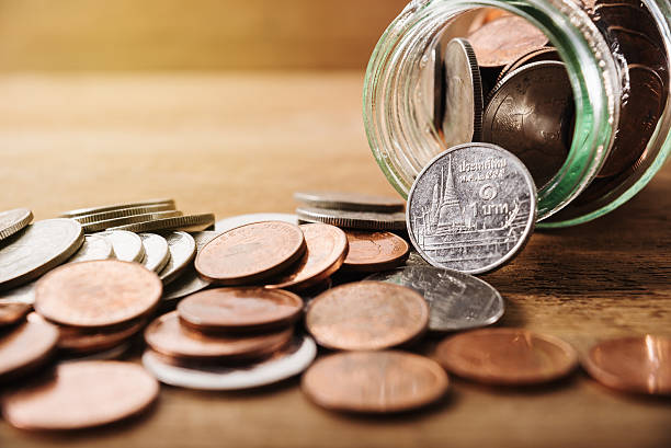 istock Coins spilling out of a glass bottle 603271590