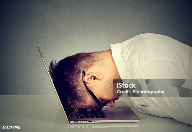 Desperate Employee Stressed Man Resting Head On Laptop Stock Photo - Download Image Now