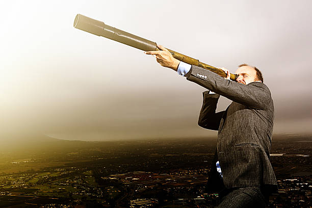istock Mountaintop businessman watching for opportunities through telescope 603276762