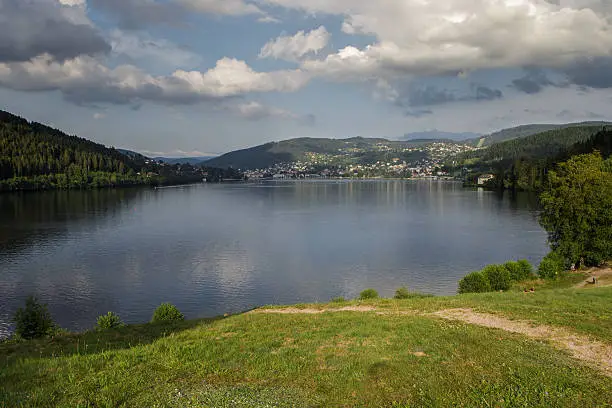 border of lake gerardmer in germany in summertime, with city at other side