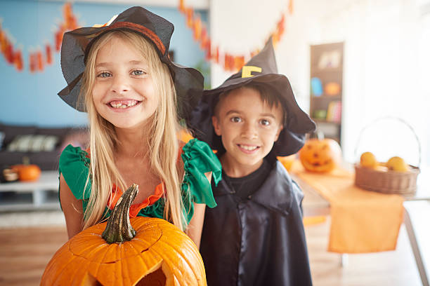 istock Brother and sister holding big pumpkin 603278818