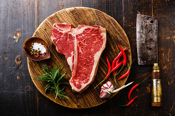 viande crue steak d’os en t, assaisonnement et couperet - red meat steak meat food photos et images de collection