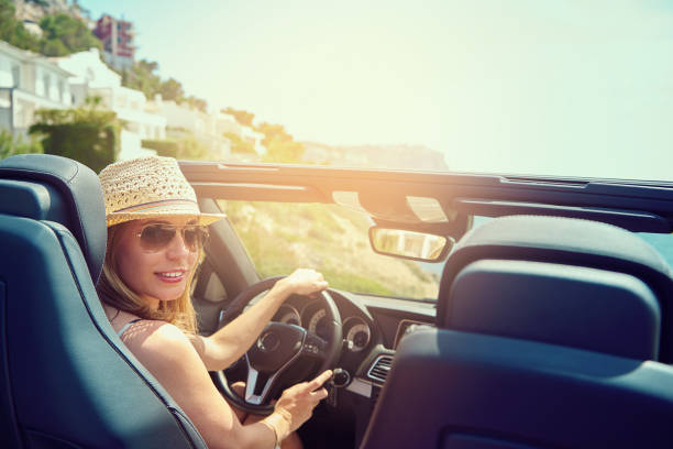 istock Young woman in convertible car looking back 603283156