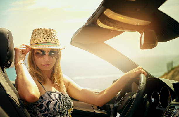 istock Smirking young woman at steering wheel 603283678