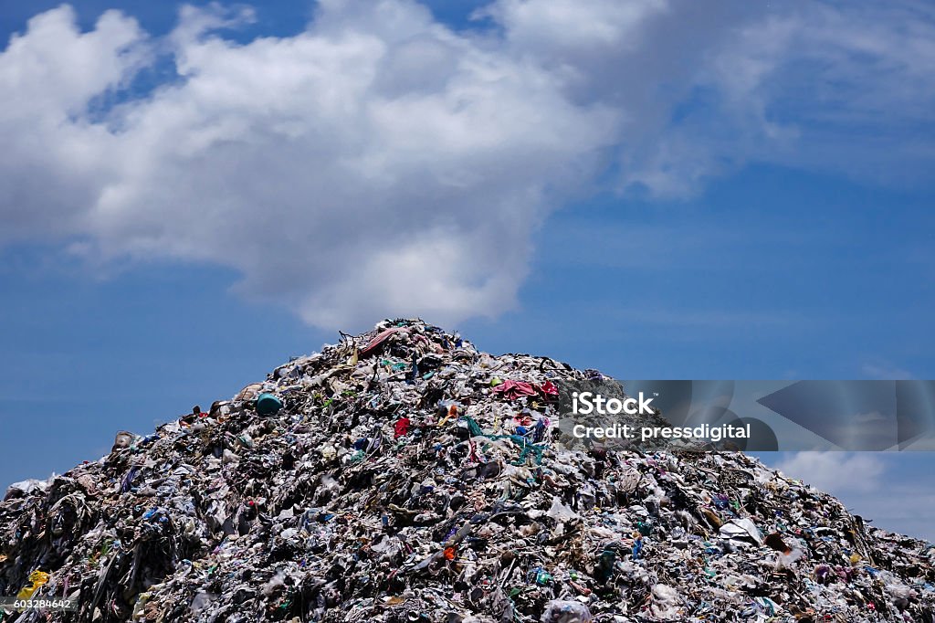 Vertedero con cielo azul y nubes cúmulo - Foto de stock de Vertedero de basuras libre de derechos