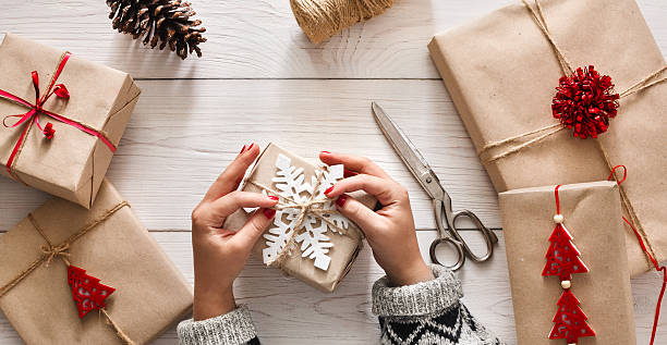 istock Woman's hands wrapping christmas holiday present with craft twine 603287018