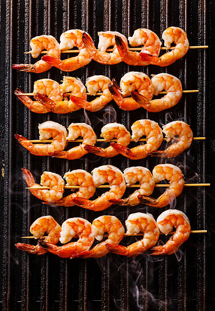 camarões fritos grelhados em espetos na grelha - prawn prepared shrimp grilled prepared tiger prawn - fotografias e filmes do acervo